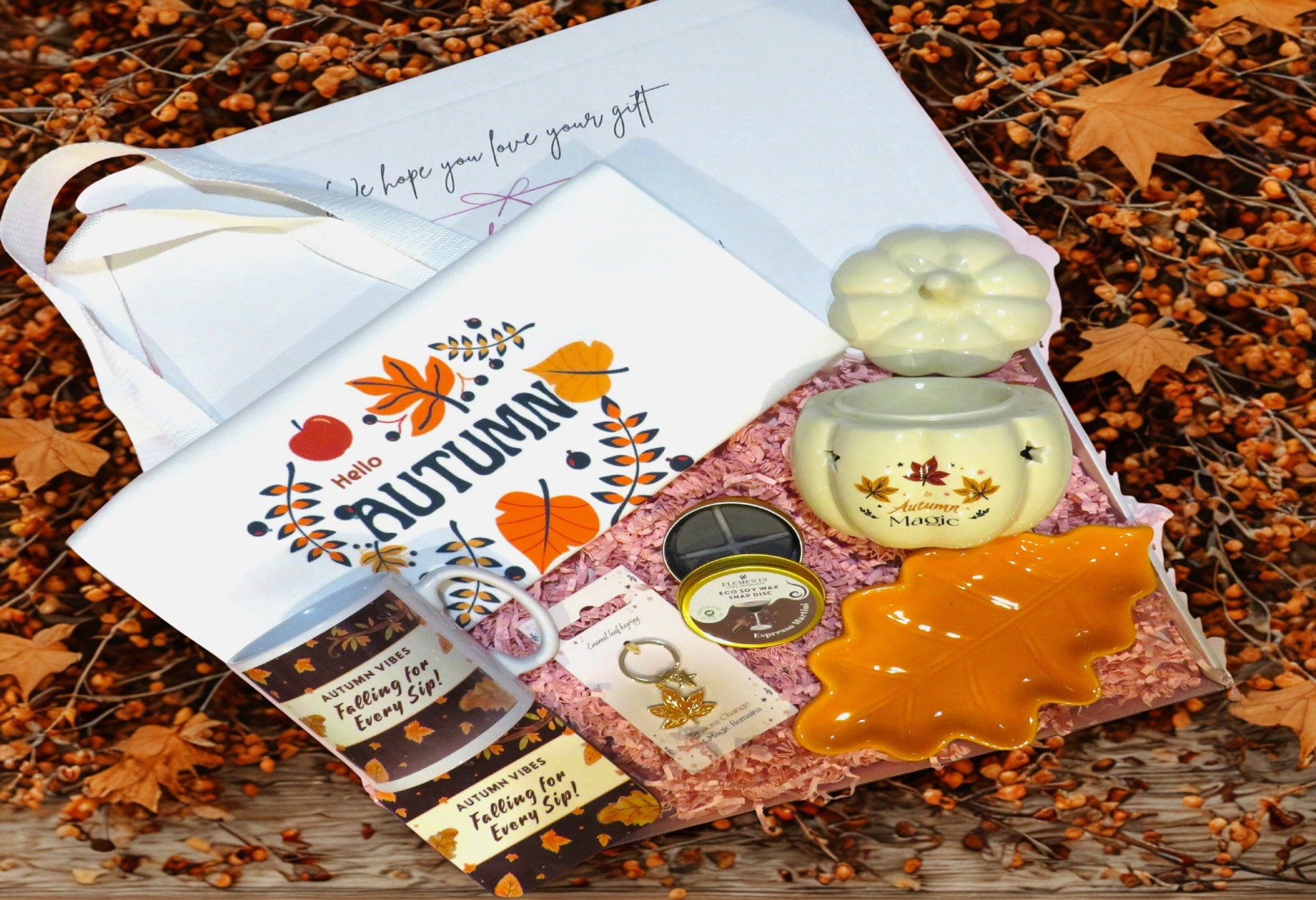 Autumn-themed gift set with a mug, & coaster, pumpkin shaped burner, orange shaped leaf trinket dish, orange leaf keyring & cocktail scented soy wax melts.