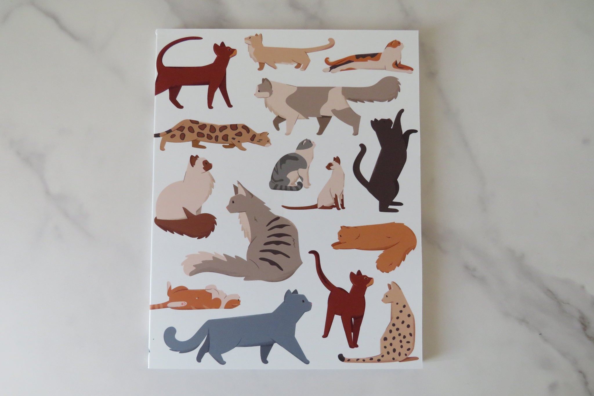Notebook with cat illustrations on.