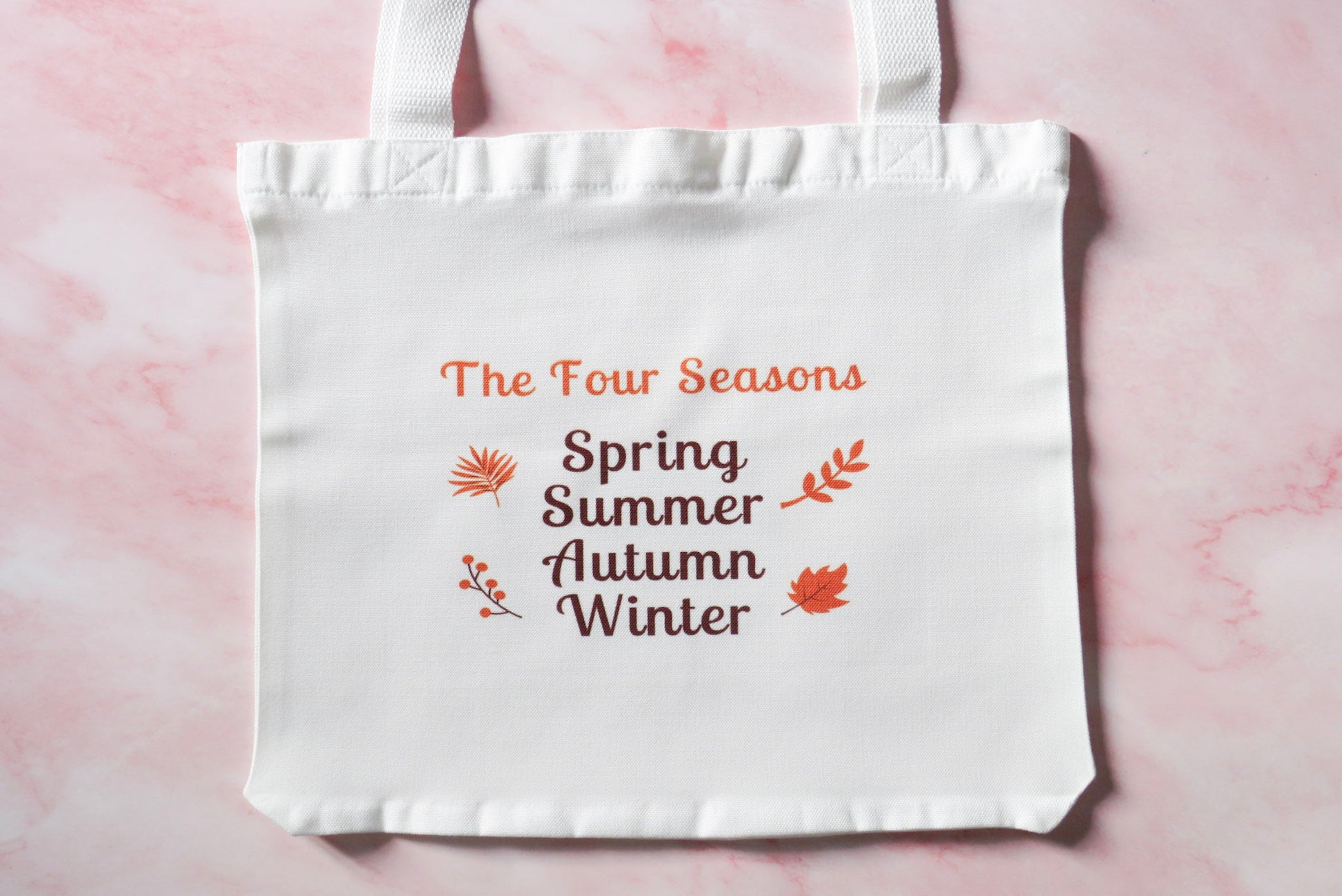 White tote bag with 'The Four Seasons' Spring, Summer, Autumn, Winter.