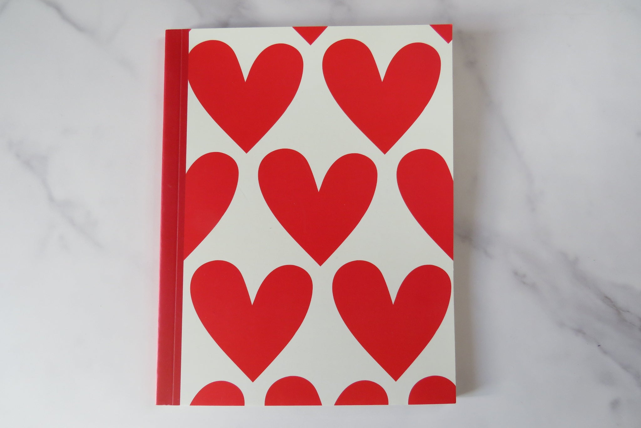 a notebook with red hearts on the cover