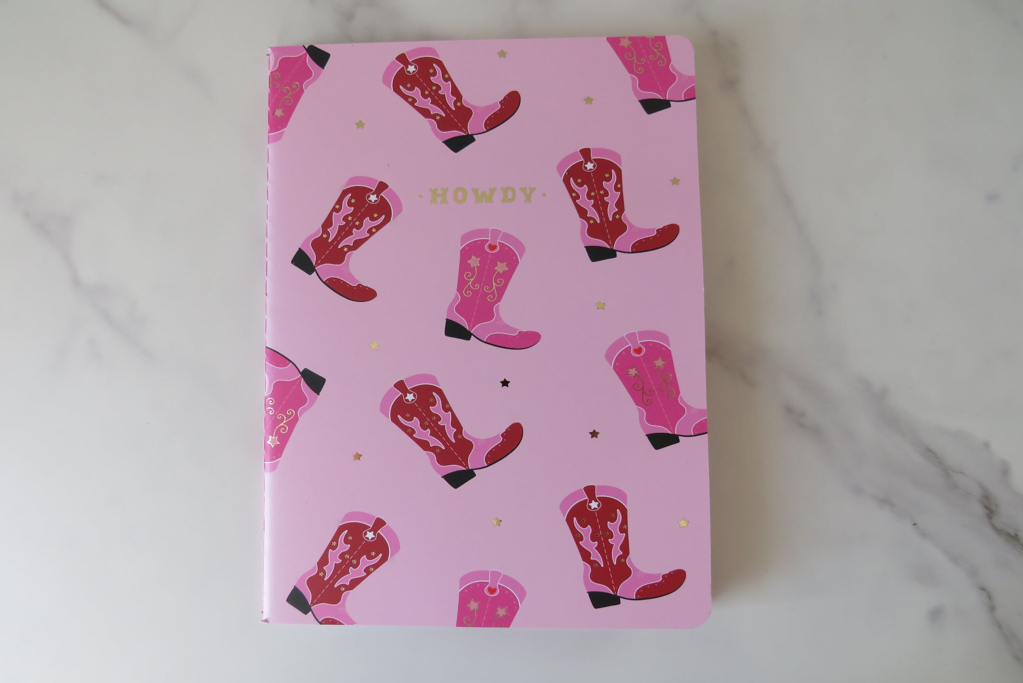 Notebook with pink cowboy boot pattern and 'Howdy' text on a pink background.