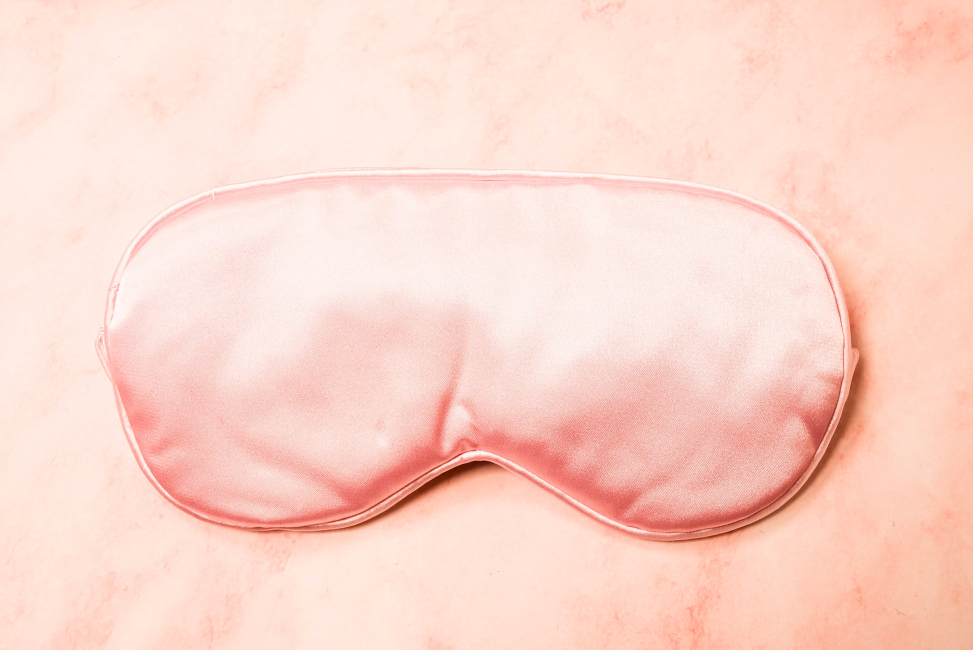 A pink silk eye mask.