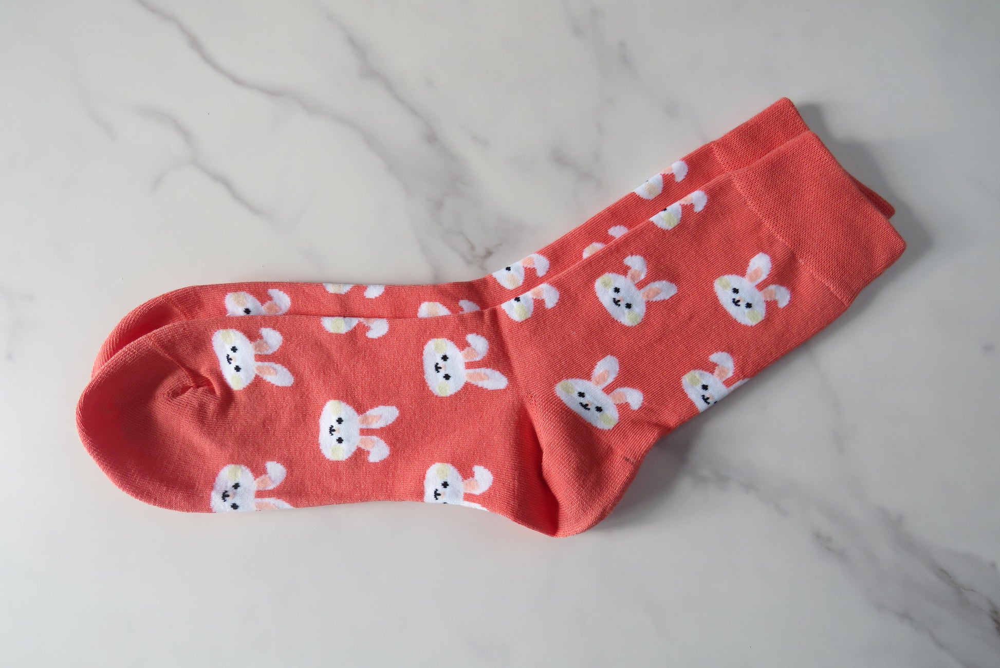 Pink socks with white bunny patterns on.