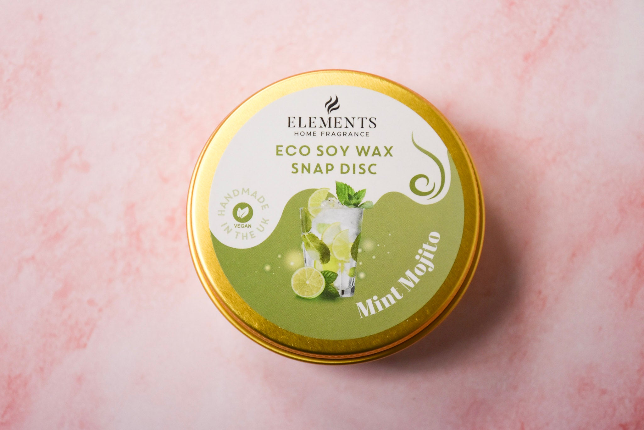 A round gold tin labelled 'Elements Home Fragrance Eco Soy Wax Snap Disc' in a Mint Mojito scent.