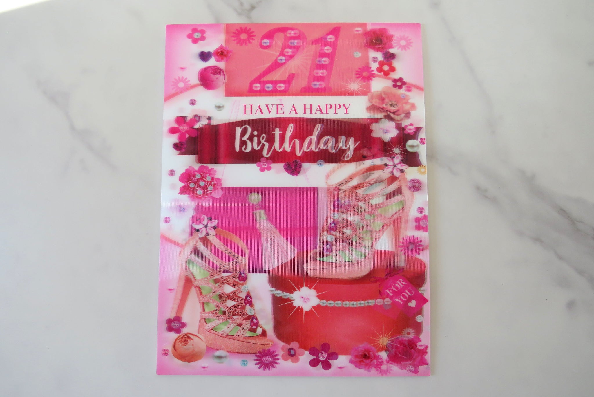 A 21st birthday card with pink and red color scheme, featuring text, decorative elements, and high-heeled shoes.