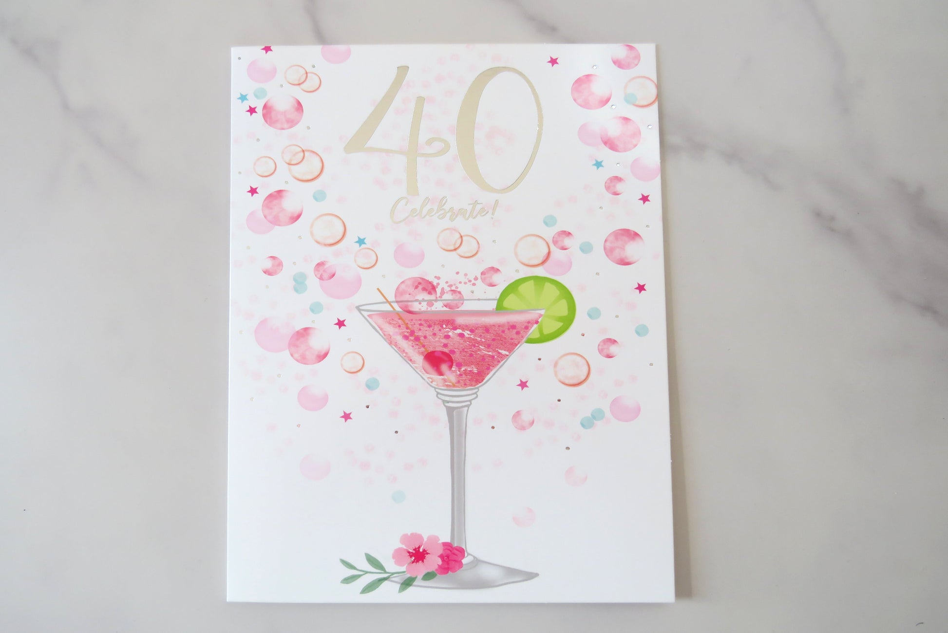 A 40th birthday card with a cocktail glass illustration, surrounded by pink rose petals.