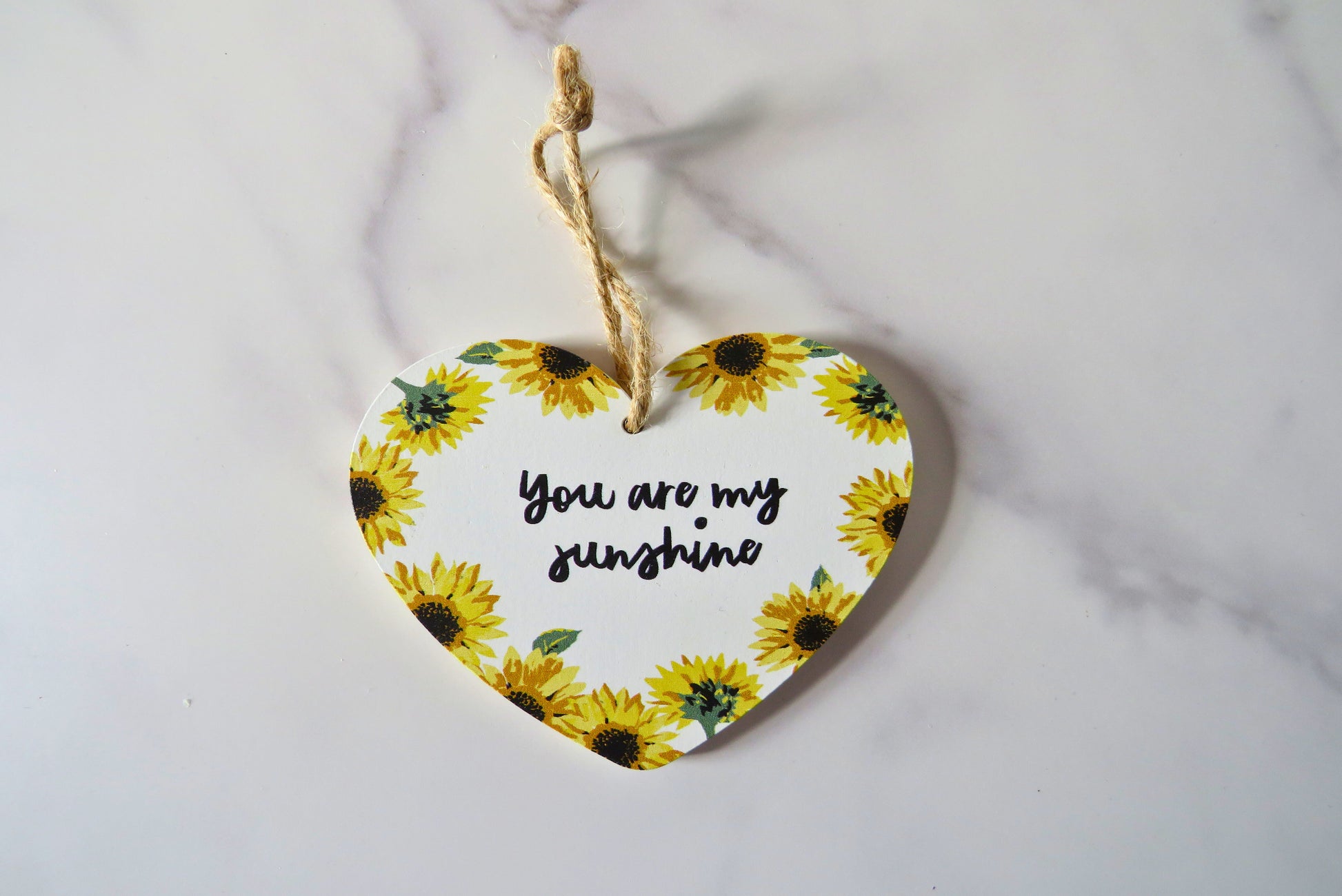 Heart-shaped decorative plaque with sunflowers and 'You are my sunshine' text on.