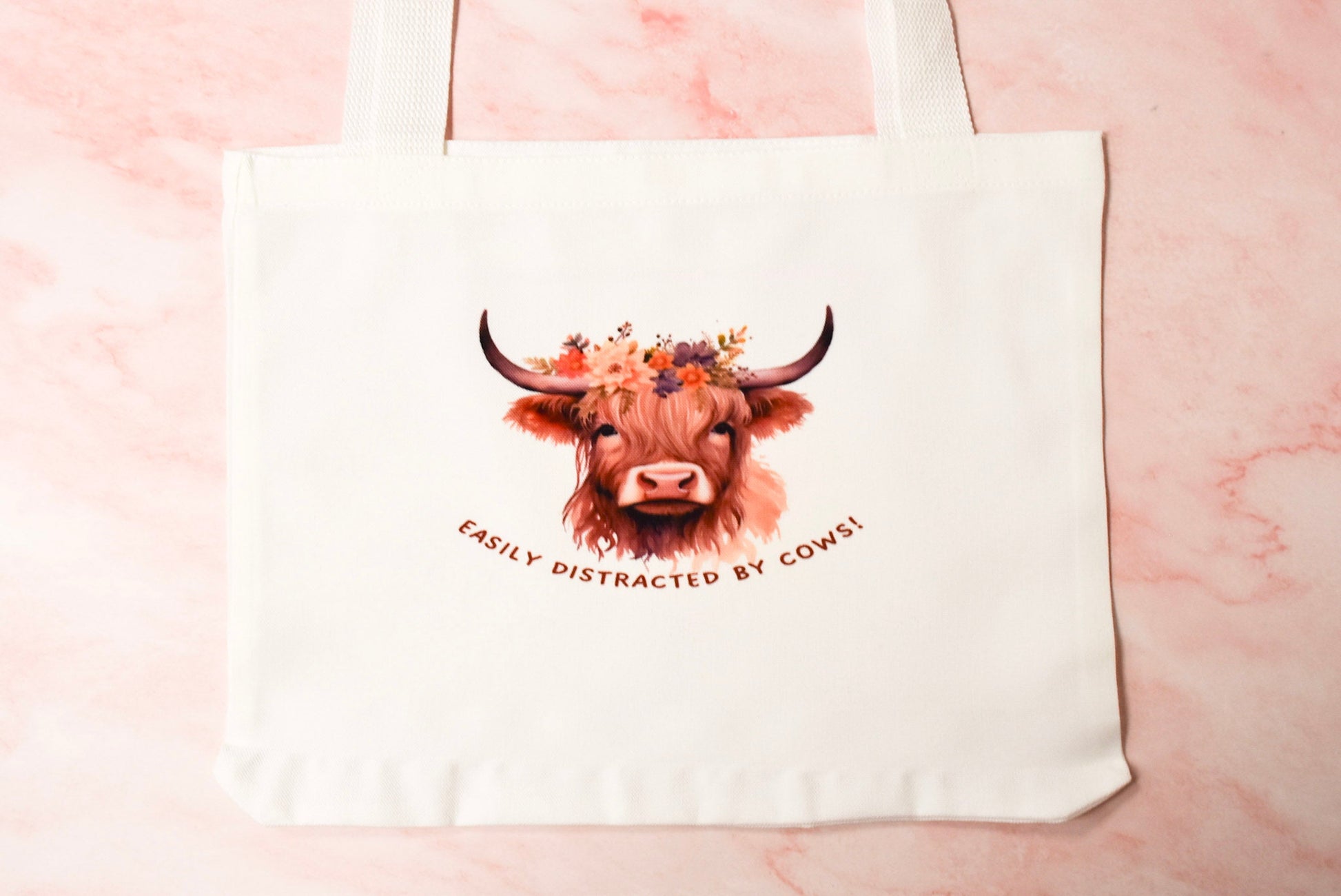 Tote bag with a highland cow design and easily distracted by cows text.