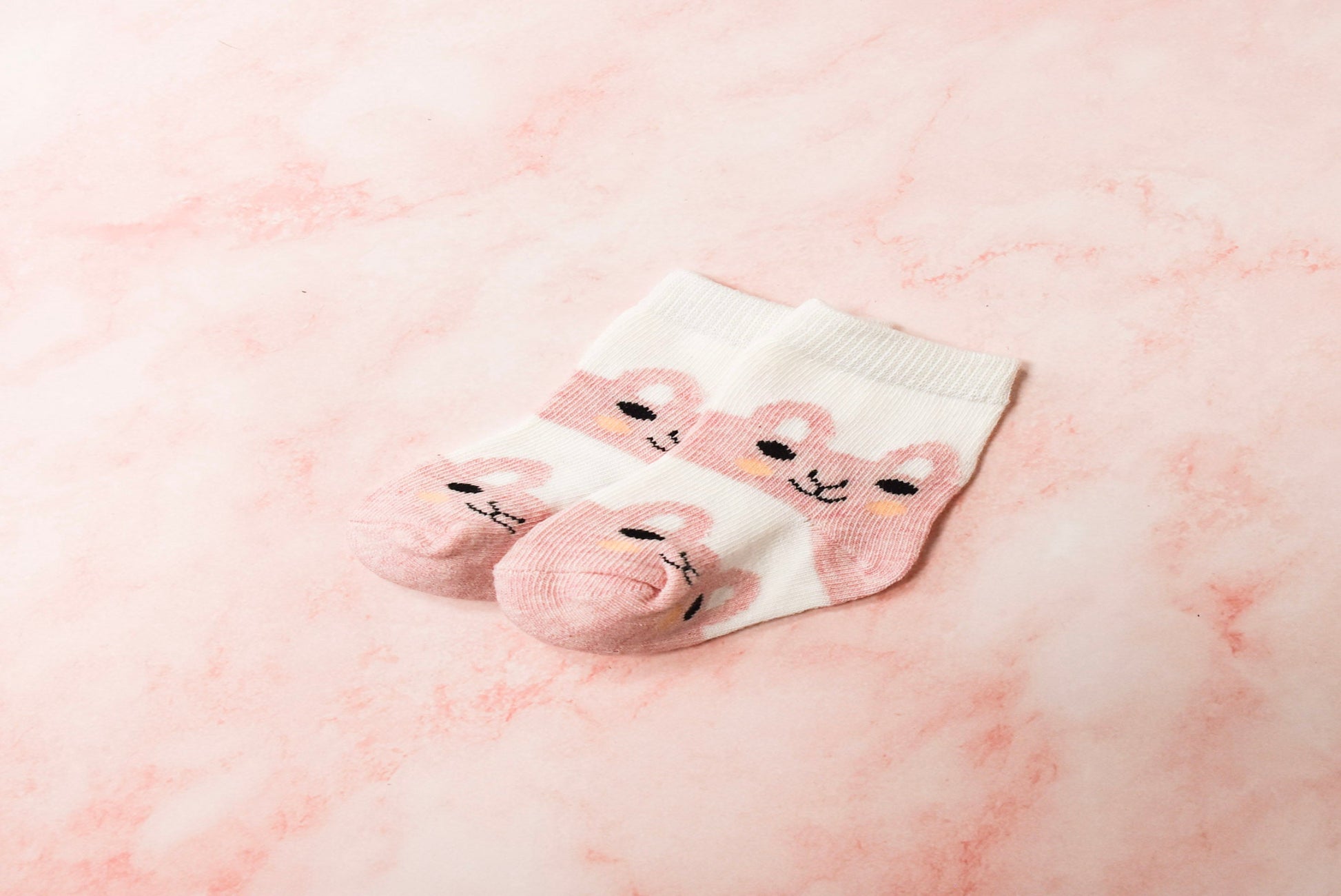 Pair of baby socks with bear design.