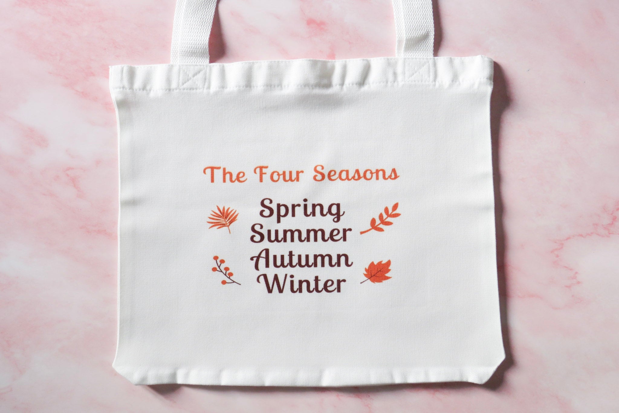 White tote bag with 'The Four Seasons' Spring, Summer, Autumn, Winter.