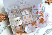 Collection of gingerbread-themed items including a mug, coaster, scented candle, cented wax melts, flower wax burner & socks.