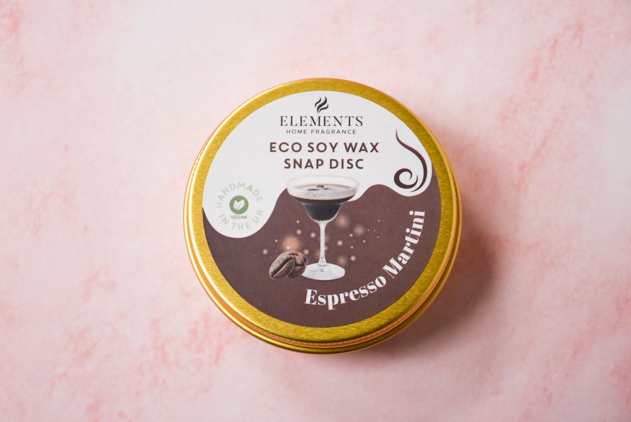 A round gold tin labelled 'Elements Home Fragrance Eco Soy Wax Snap Disc' in a Espresso Martini scent.